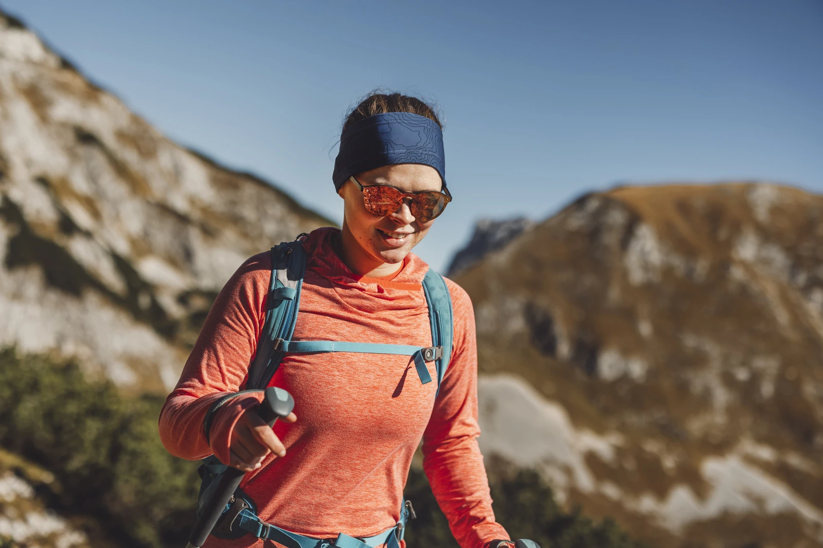 Woman hiking with trekking poles in the mountains
